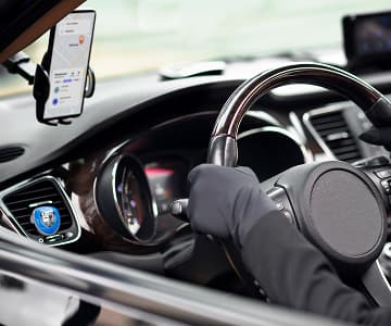 Smartphone displaying taxi service app in a car